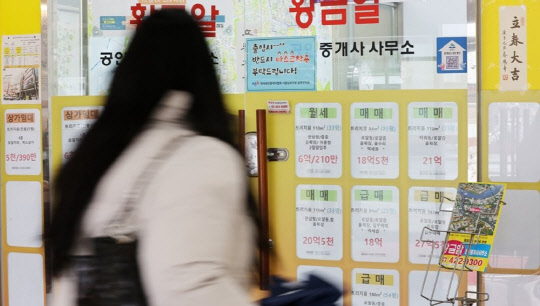 한 시민이 부동산공인중개업소 매물정보 게시판에 붙은 시세를 살펴보고 있다. <연합뉴스>